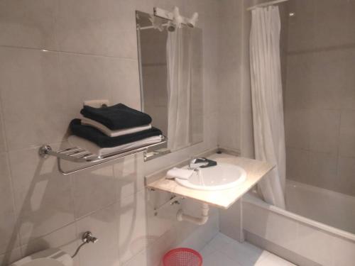 a white bathroom with a sink and a shower at Casa de mamá in Santiago de Compostela