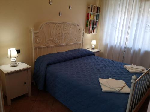 a bedroom with a bed with a blue comforter and two lamps at Domus Cornelia in Naples