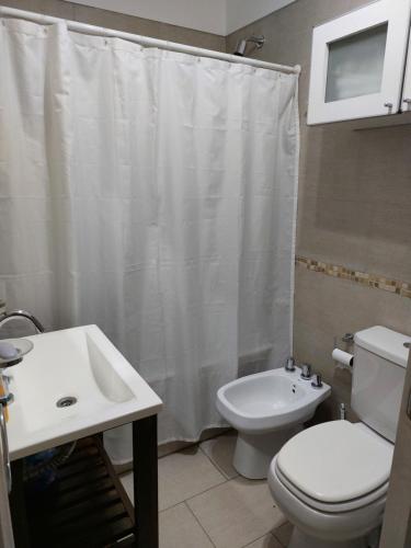 uma casa de banho com um WC branco e um lavatório. em Dto Tejedor em Mariano J. Haedo