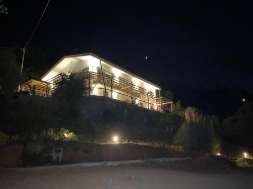 Una casa iluminada en una colina por la noche en Villa Patrizia Pietrasanta en Pietrasanta