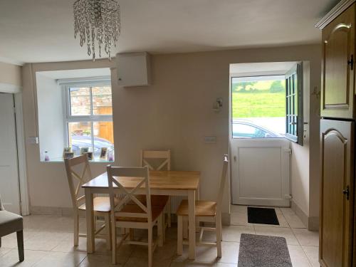 uma sala de jantar com uma mesa de madeira e cadeiras em Toms Cottage em Longford