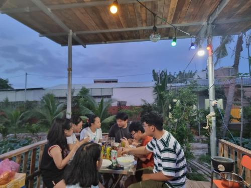 un grupo de personas sentadas en una mesa comiendo comida en Homestay Sen & Zen Villa Vũng Tàu en Vung Tau