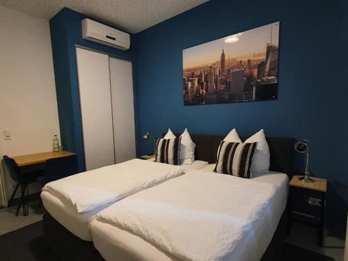 2 camas en una habitación de hotel con paredes azules en Argenta Living 131 en Künzell
