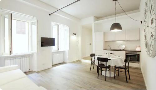 Habitación blanca con mesa y sillas. en Trastevere Residence, en Roma