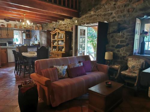 a living room with a couch and a table and a kitchen at Casa do Sapateiro - piscina in Valença