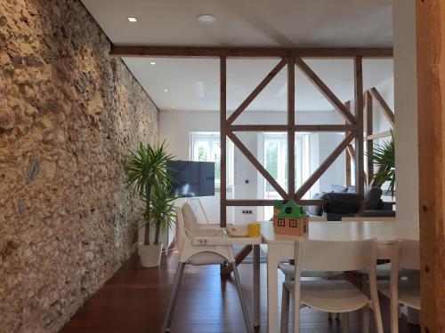 a dining room with a stone wall and a table and chairs at 1881 Historical duplex Suite in Lisbon