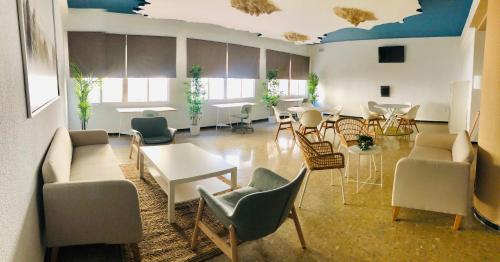 Habitación grande con sillas, mesas y sillas. en Costa De La Luz, en Huelva
