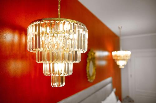 a chandelier hanging from a red wall at La Rose Residence in Mikołajki