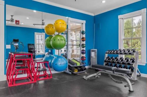 a gym with blue walls and equipment in a room at Heartbeat Of ATL- Gated Community, Pool, Gym, and much more! in Atlanta