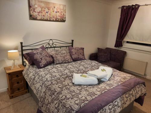una camera con un letto con due cuscini sopra di Ardfern Apartments ad Airdrie