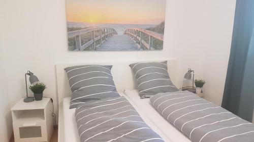 a bedroom with a bed with striped pillows and a bridge at Sea Cloud White Line in Eckernförde