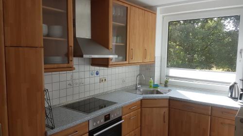 a kitchen with wooden cabinets and a sink and a window at Sea Cloud White Line in Eckernförde