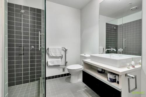 a bathroom with a toilet and a sink and a shower at QV Waterfront Apartment Viaduct Area - 503 in Auckland