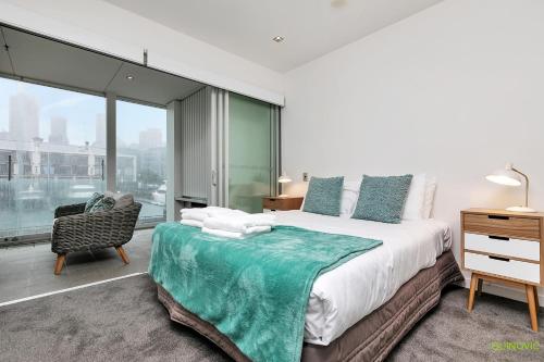 a bedroom with a large bed and a window at QV Waterfront Apartment Viaduct Area - 503 in Auckland