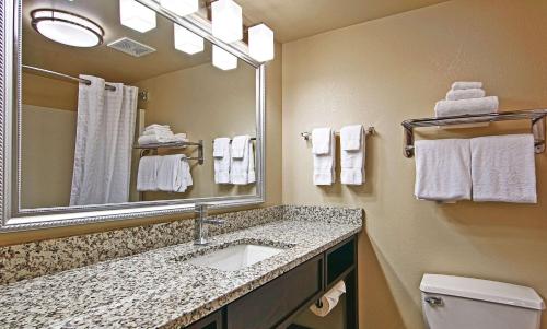 a bathroom with a sink and a mirror and towels at Comfort Inn & Suites Copley Akron in Copley