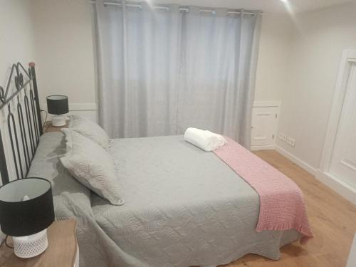 a bedroom with a large bed with a pink blanket at CASA PEREIRAS in Pontevedra