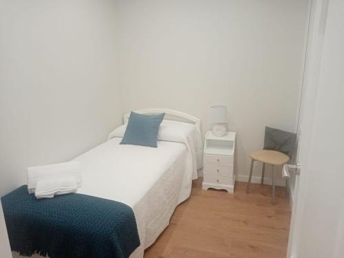 um pequeno quarto com uma cama e um banco em CASA PEREIRAS em Pontevedra