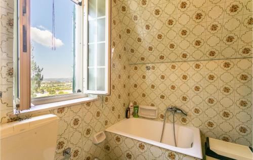 ein Bad mit einer Badewanne, einem Waschbecken und einem Fenster in der Unterkunft 3 Bedroom Cozy Home In Noto in Noto