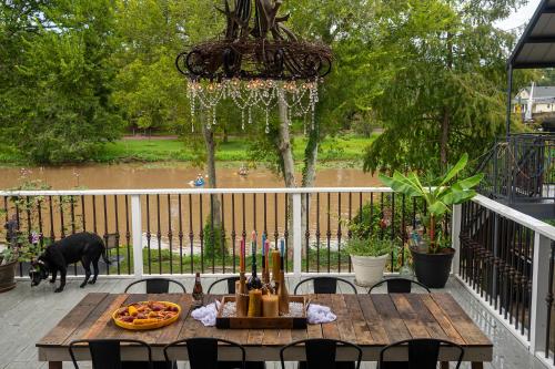 a dog standing on a deck with a table and a dog at Chateau Royale, Pet Friendly, On Bayou, Downtown! in New Iberia