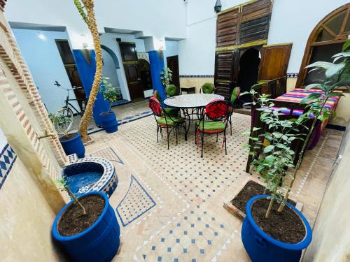 a patio with a table and chairs and potted plants at Archduke private rooms in Marrakech
