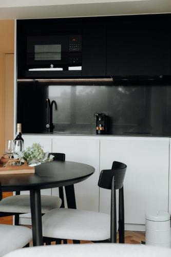 a kitchen with a table with chairs and a microwave at JARS Apartments - Casa do Bessa in Porto