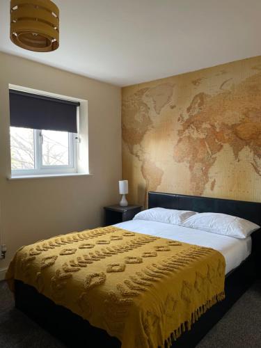a bedroom with a large bed with a map on the wall at Cheerful 3 Bedroom Town House With Hot Tub in Blackpool