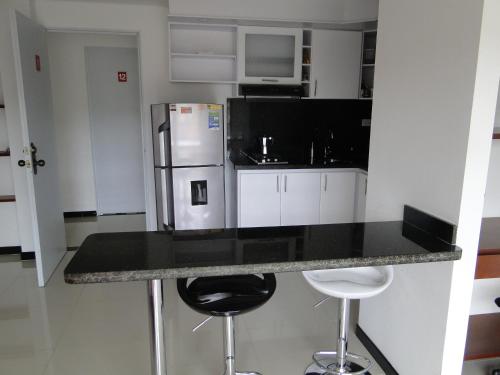 a kitchen with a refrigerator and two bar stools at Hotel Campestre Villa Juliana in Chía