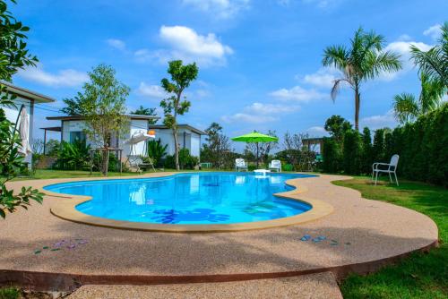 a swimming pool in a yard with a house at Baan Suan Thanwalai Khon Kaen in Khon Kaen