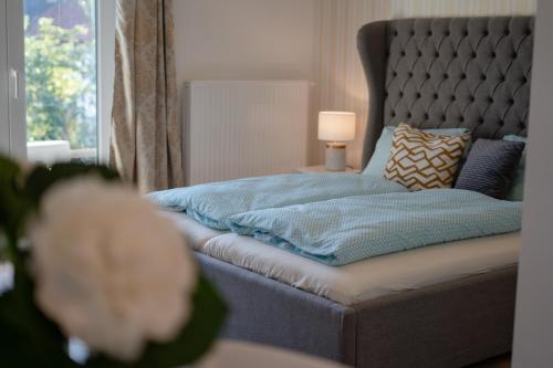 a bed with a blue blanket and a lamp on a table at Rooms21 in Schiefling am See