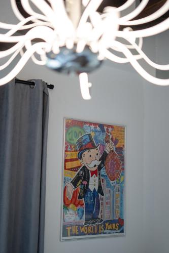 a painting on a wall next to a chandelier at Rooms21 in Schiefling am See