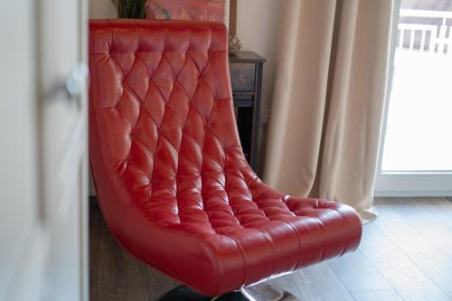 a red leather chair in front of a door at Rooms21 in Schiefling am See