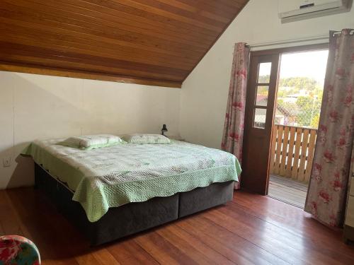 1 dormitorio con 1 cama y puerta corredera de cristal en Chalé dos Ingleses, en Florianópolis
