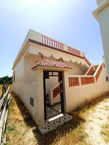 a small house with a door in a field at Calm Coast Villa in Agaouz