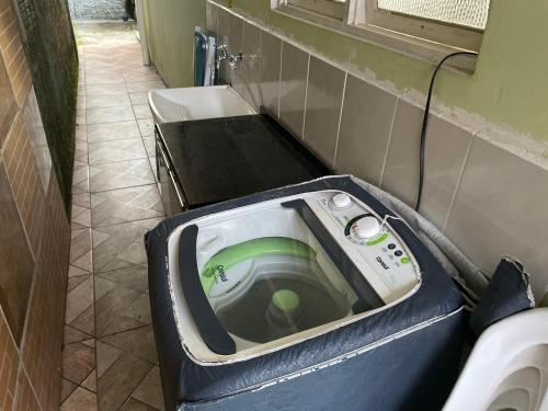 y baño con aseo y lavadora. en Chalé dos Ingleses, en Florianópolis