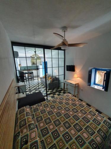 - une chambre avec un lit et un ventilateur de plafond dans l'établissement CASA VERA, à Vejer de la Frontera