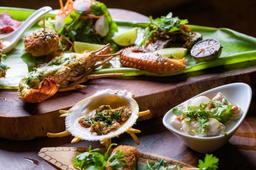 a table topped with different types of seafood and vegetables at La Cozinha Bungalow in Barra Grande