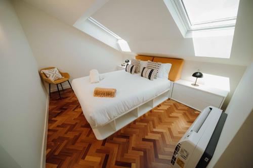 a small attic bedroom with a bed and a skylight at JARS Apartments - Casa do Bessa in Porto