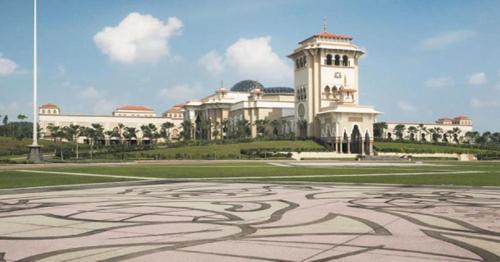 a large building with a clock tower in front of a courtyard at Here Hotel in Skudai