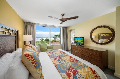 a bedroom with a bed and a mirror and a television at Luxury Beach Front Resort in Fort Myers Beach