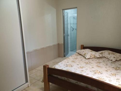 a bedroom with a bed with a window and a shower at Casa Damasco in Florianópolis