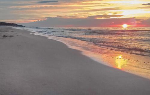 a sunset on a beach with the ocean at 2 Bedroom Gorgeous Home In Wolin in Wolin