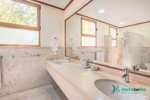 baño con 2 lavabos y espejo grande en Be relaxed at this 2BR apt at Casa De Campo en Buena Vista
