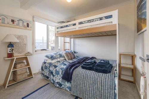 Cape PatersonにあるCapes Coastal Charmerのベッドルーム1室(ベッド1台、二段ベッド1組付)
