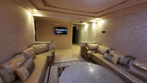 una sala de espera con sofás y TV de pantalla plana. en اقامة ريان, en Nador