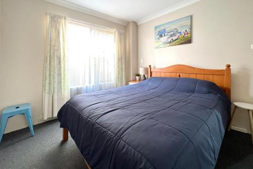 a bedroom with a large bed and a window at Braemar 9 in Forster