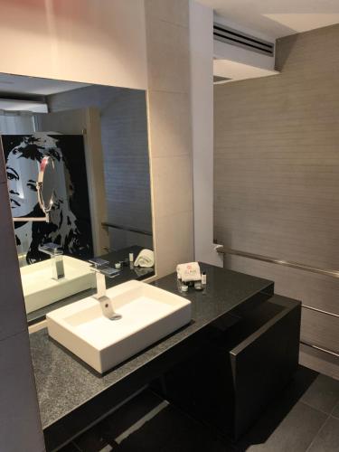 W łazience znajduje się biała umywalka i lustro. w obiekcie MOTEL BOUTIQUE GLAM w mieście San José de Otates