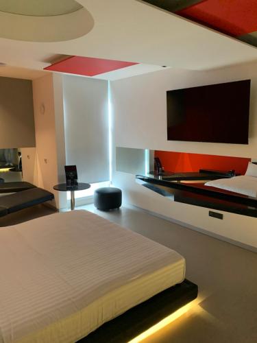 a bedroom with a bed and a flat screen tv at MOTEL BOUTIQUE GLAM in San José de Otates