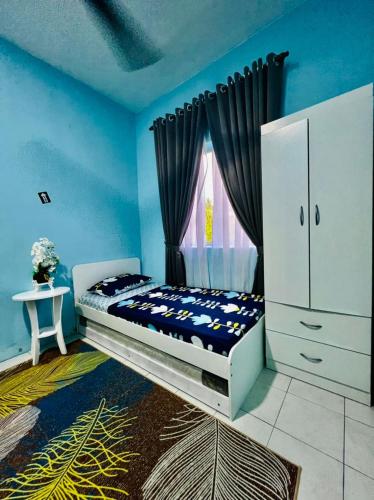 a bedroom with a bed and a window at CEMPAKA IRIS HOMESTAY in Kampung Bota Kiri