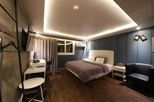 a bedroom with a bed and a desk and a couch at Hotel Frenchcode in Busan