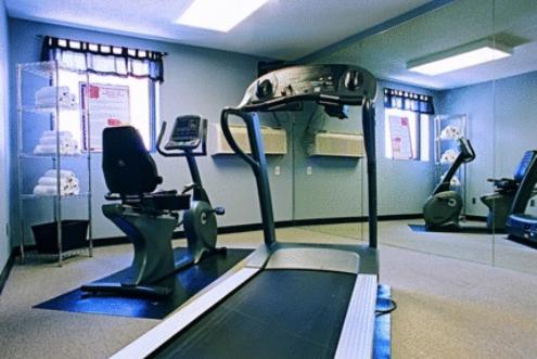 a gym with a treadmill and chairs in a room at Americas Best Value Inn St. Louis / South in Saint Louis